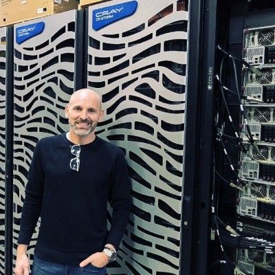 Bronson Broer standing in front of Cray supercomputer cabinets in a data center